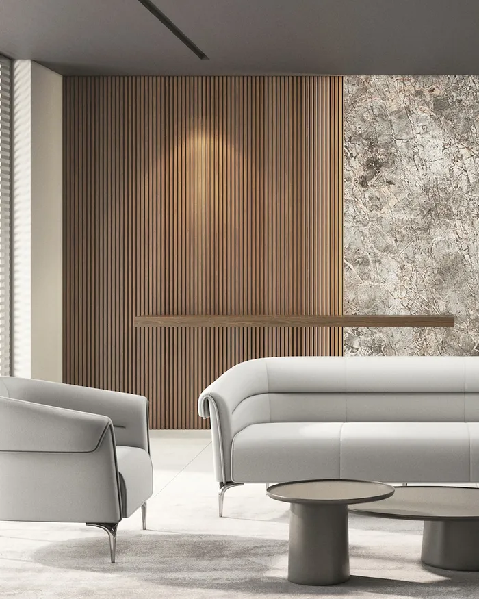 Sala de espera con sofá y sillones tapizados en gris claro y mesa de centro