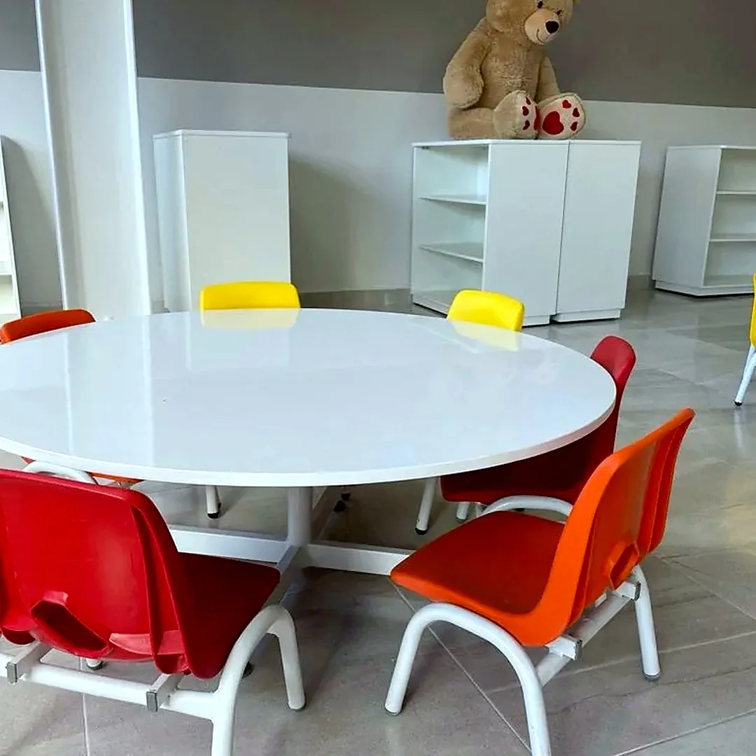 Mesa redonda con sillas infantiles rojas y amarillas