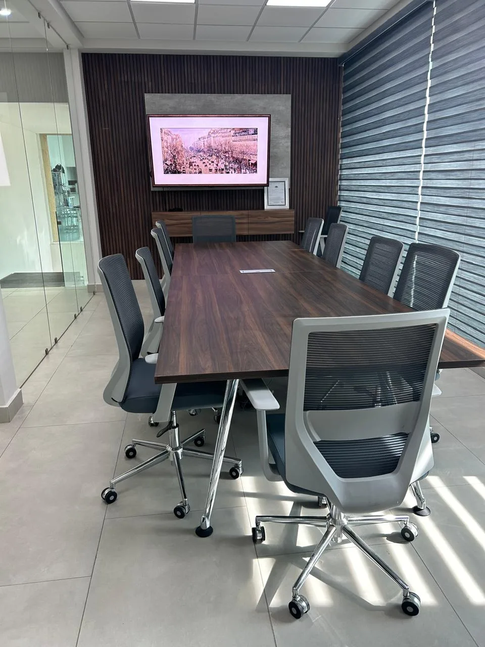 Sala de juntas con mesa de madera y sillas de malla